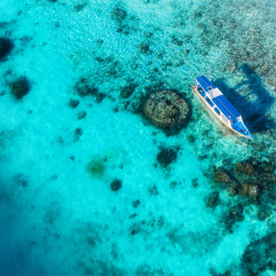 Boats on the water surface and beach from top view. Azure water background from drone. Summer seascape from air. Travel - image